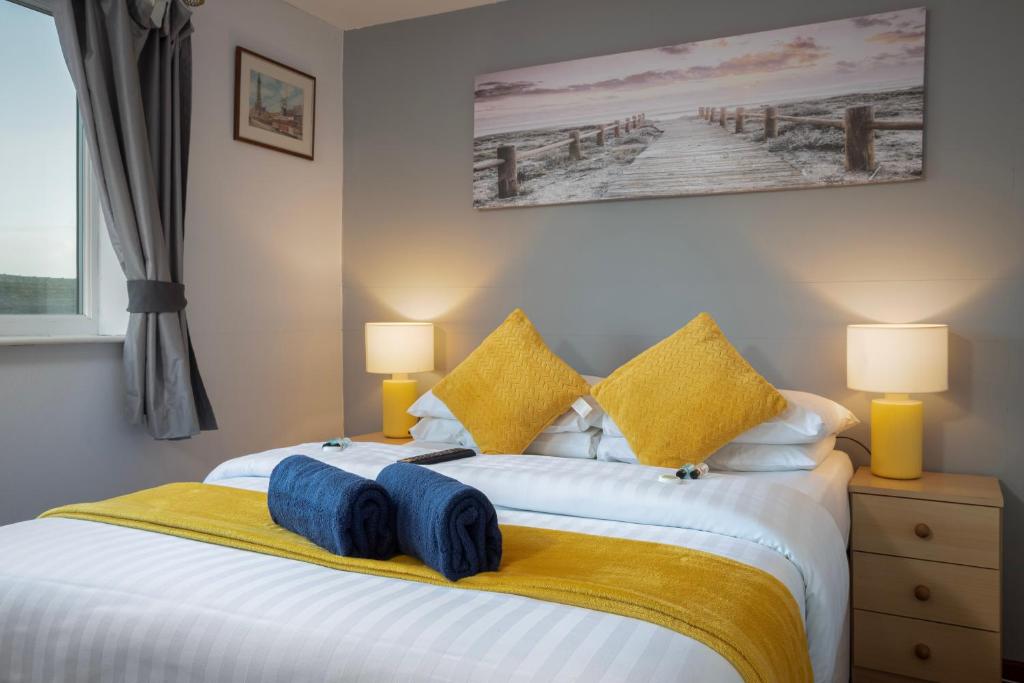 a bedroom with a large white bed with yellow pillows at Royal Oakwell Hotel in Blackpool
