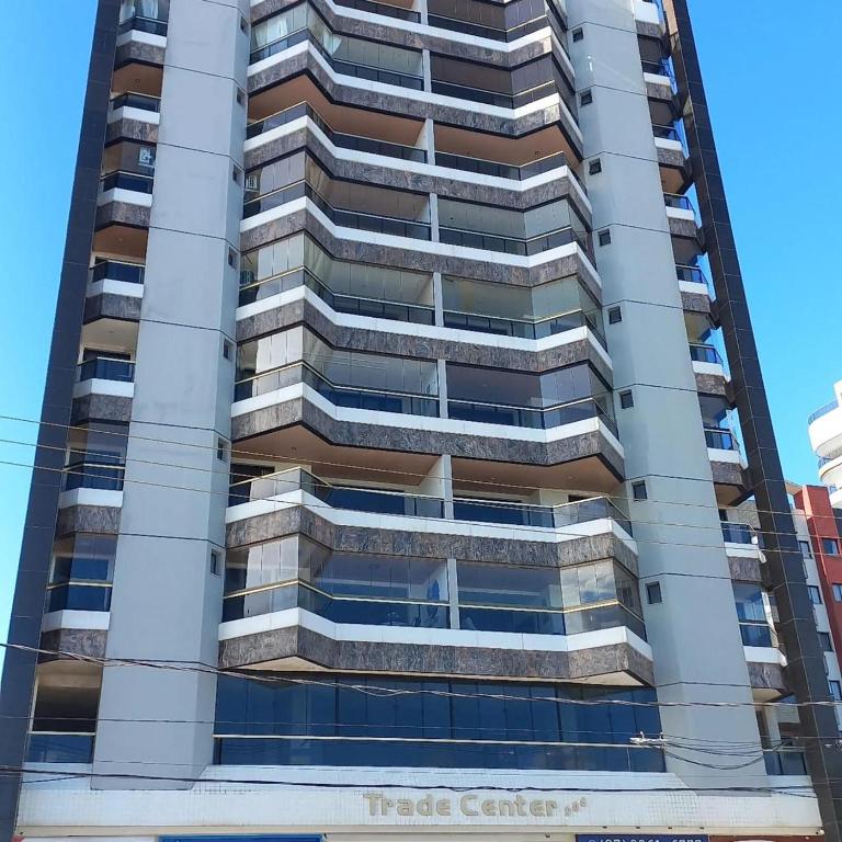 un edificio alto con un cartello di un centro commerciale sopra di Apartamento Beira-mar a Guarapari