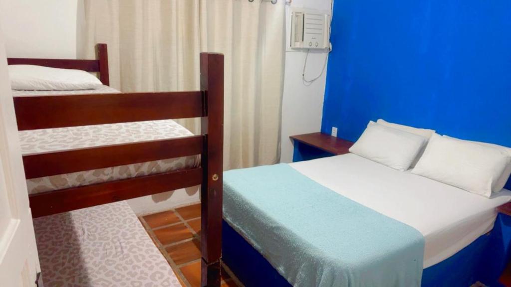 een slaapkamer met 2 stapelbedden en een blauwe muur bij Praia dos Anjos Suítes in Arraial do Cabo