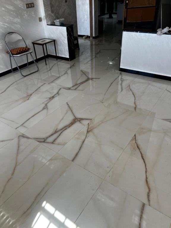 een witte marmeren vloer in een kamer met een tafel bij Dar rahma in Khenifra
