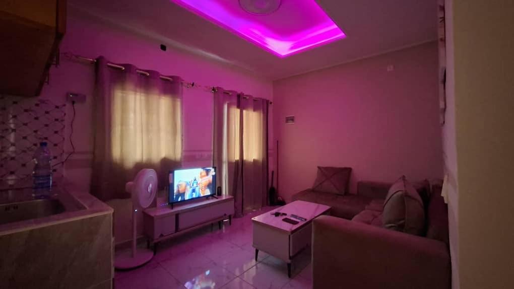 un soggiorno con un divano e una TV di Bienvenue chez vous a Libreville