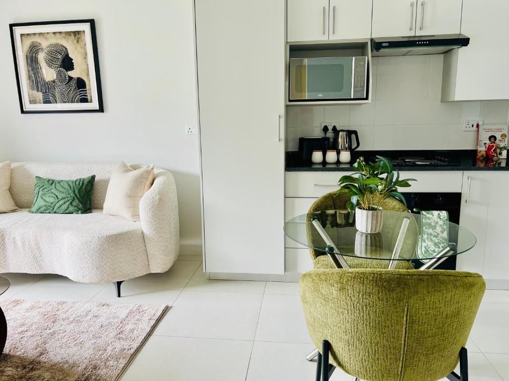 a living room with a glass table and a couch at Cozy Habitat in Gaborone