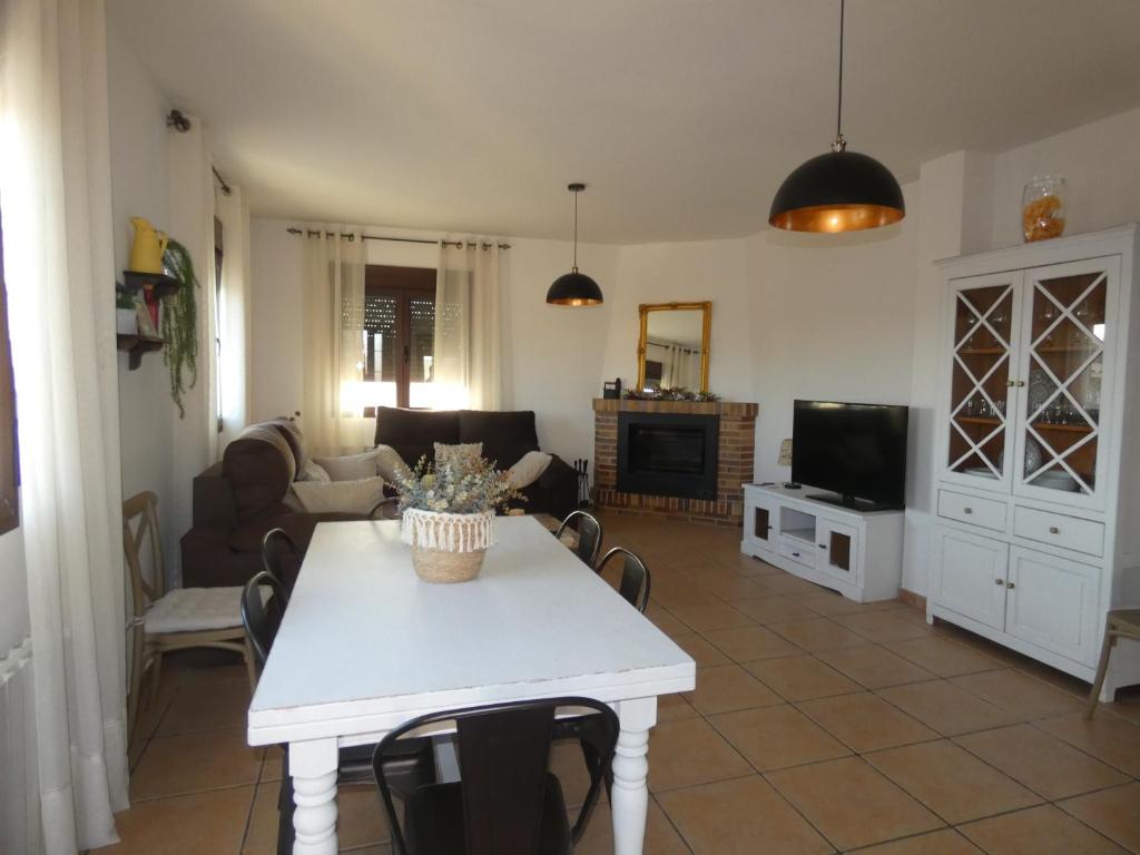 un soggiorno con un tavolo e una tv di El Refugio de Hugo a Benablón