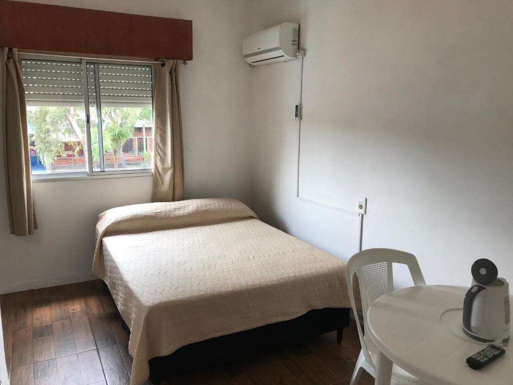 een kleine kamer met een bed en een tafel bij Departamentos LT3 in Las Toscas