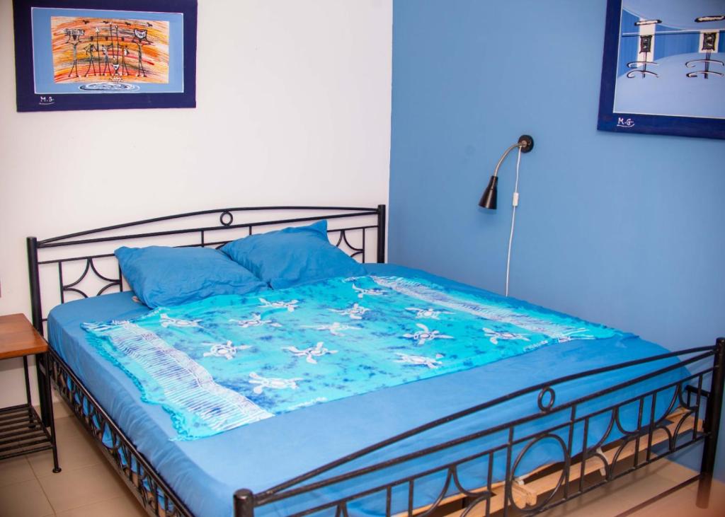 a blue bedroom with a bed with a blue comforter at 20 ' keur in Boukot Ouolof