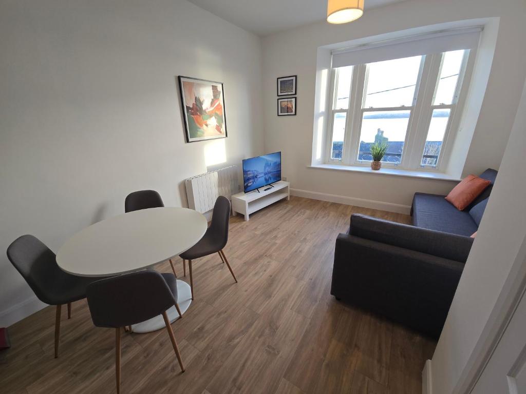 een woonkamer met een tafel en een bank bij 2 Bed Apartment with Harbour Views Apt 2 in Cobh