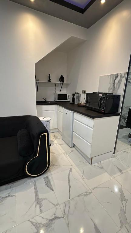 una cucina bianca con bancone e forno a microonde di Le Cocoon a Nevers