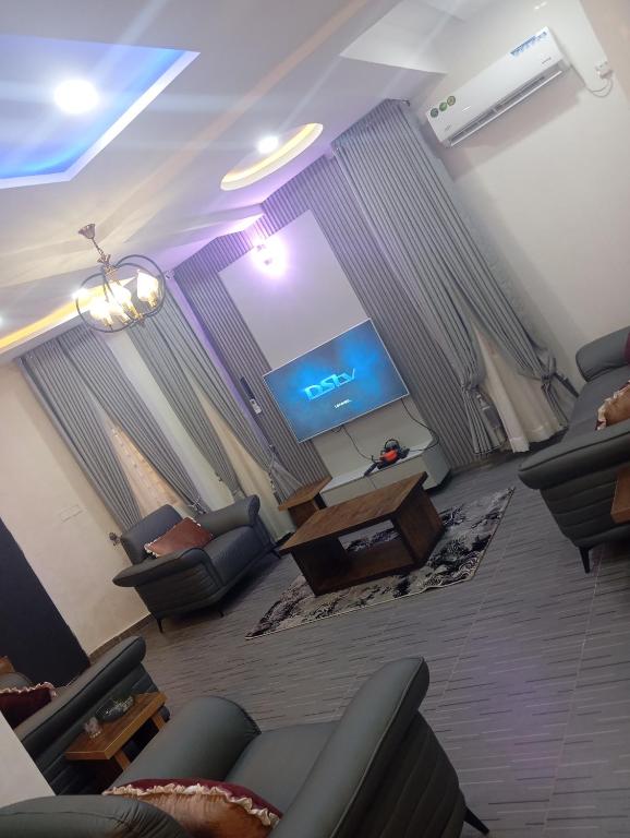 a living room with couches and a flat screen tv at Luxury 3 Bedroom Duplex with Mini Swimming Pool in Enugu
