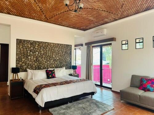 a bedroom with a large bed and a couch at Los Suspiros Hotel Boutique & Spa in Comala