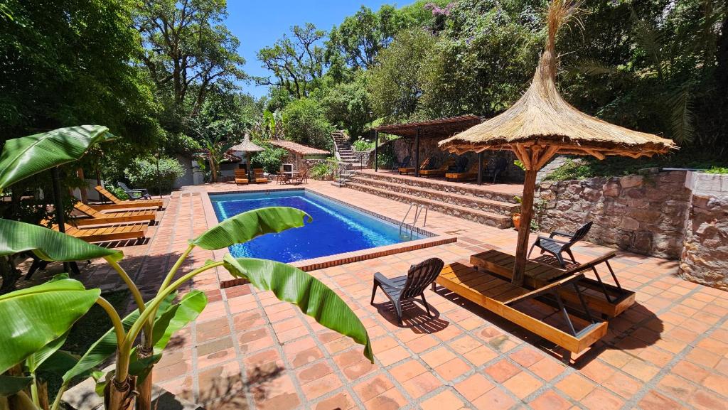 - une piscine avec des chaises et un parasol dans l'établissement Hotel Selva Montana, à San Lorenzo