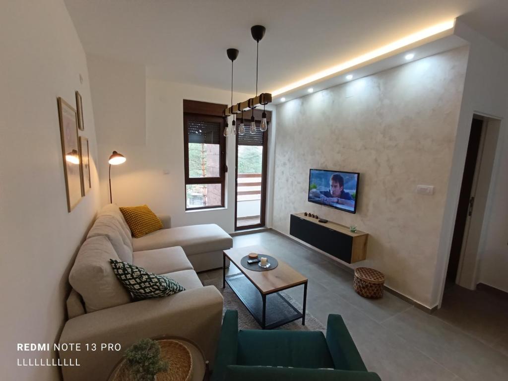 een woonkamer met een bank en een tafel bij Pino Silvestre Divčibare in Divčibare