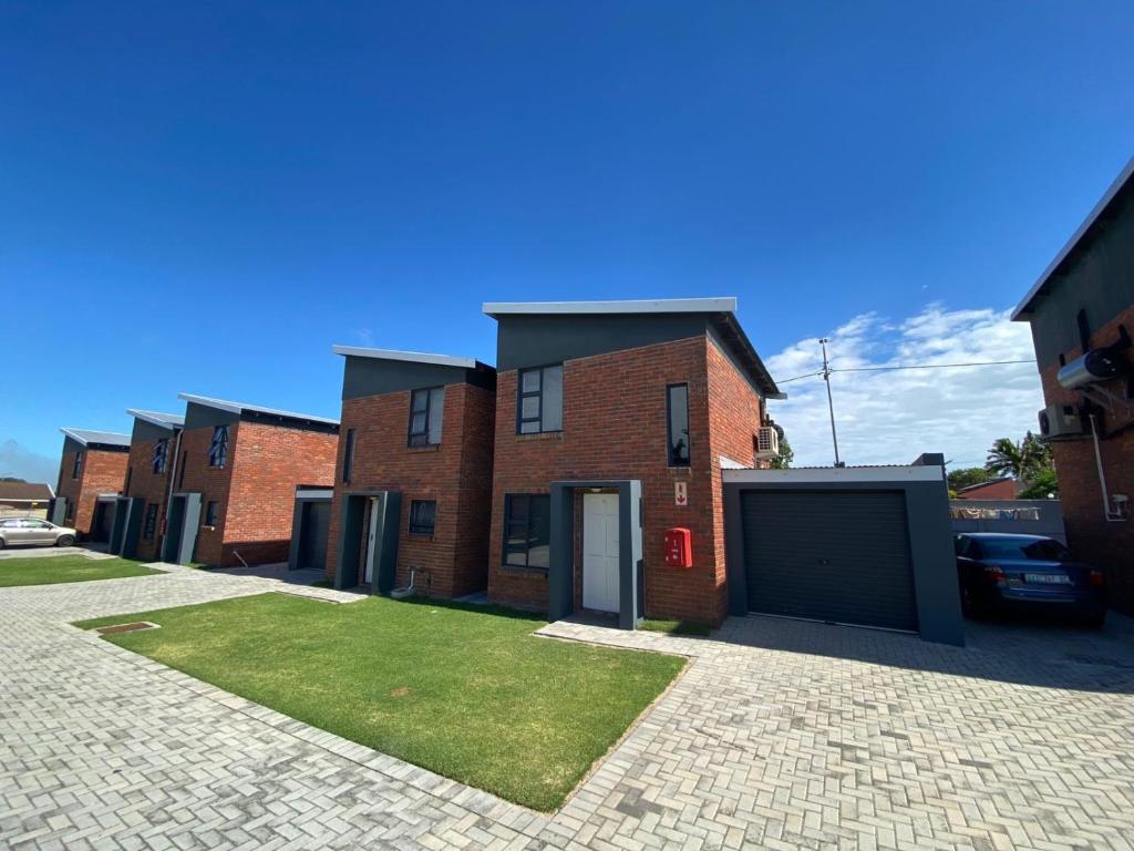 un bâtiment en briques avec un garage dans une allée. dans l'établissement Exclusive Townhouse at The Square, à Port Elizabeth