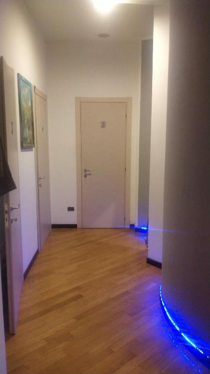 een lege kamer met een houten vloer en een witte deur bij Mini Hostel 404 in Turijn