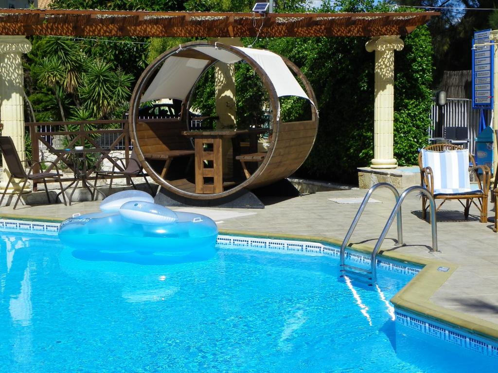 a swimming pool with a large mirror next to a swimming pool at Mirabelle Hotel in Argassi