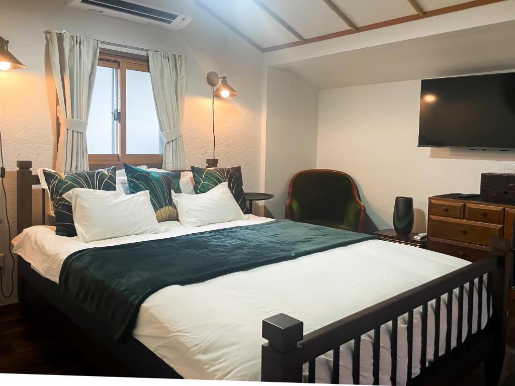 une chambre avec un grand lit et une télévision dans l'établissement Kokoro no Yado, à Nara