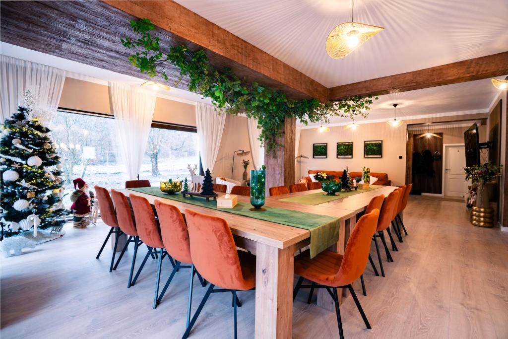 a dining room with a long table and a christmas tree at Imperial Home Chalet in Sibiu