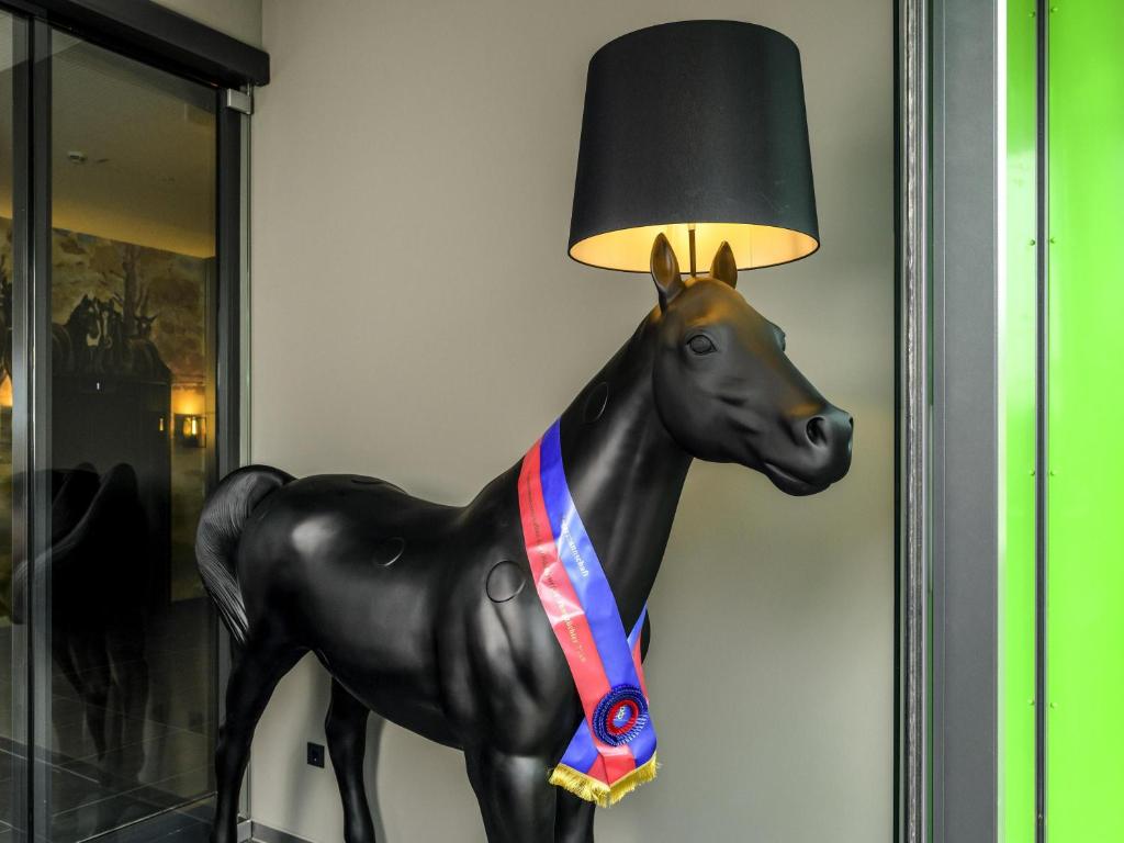 a statue of a horse with a lamp on a wall at ibis Styles Vechta in Vechta