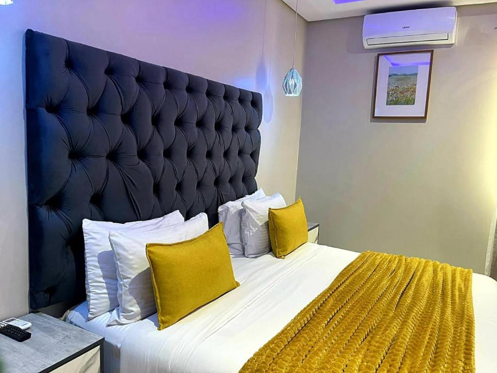 a bedroom with a large bed with yellow pillows at Swiss Guest Lodge in Boksburg