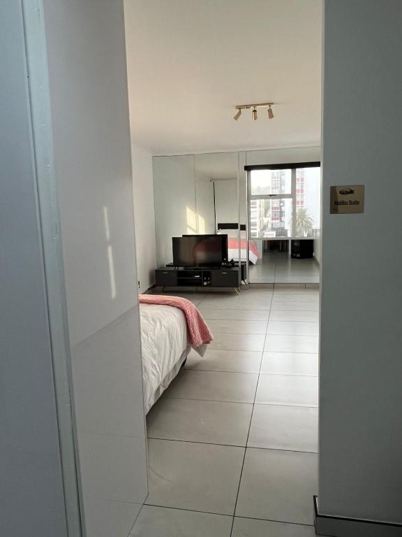 a bedroom with a bed and a large mirror at Malibu Dream in Gqeberha