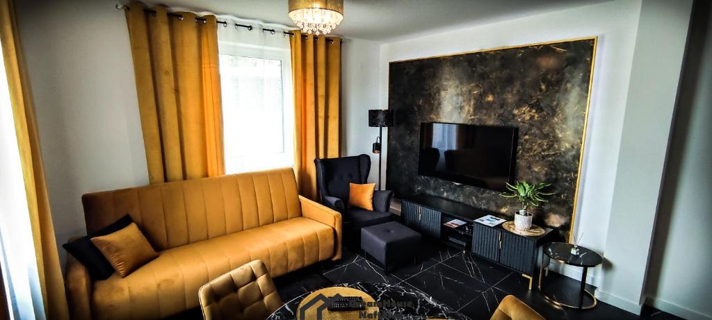 een woonkamer met een bank en een televisie bij Dream House Naftowa in Ustrzyki Dolne