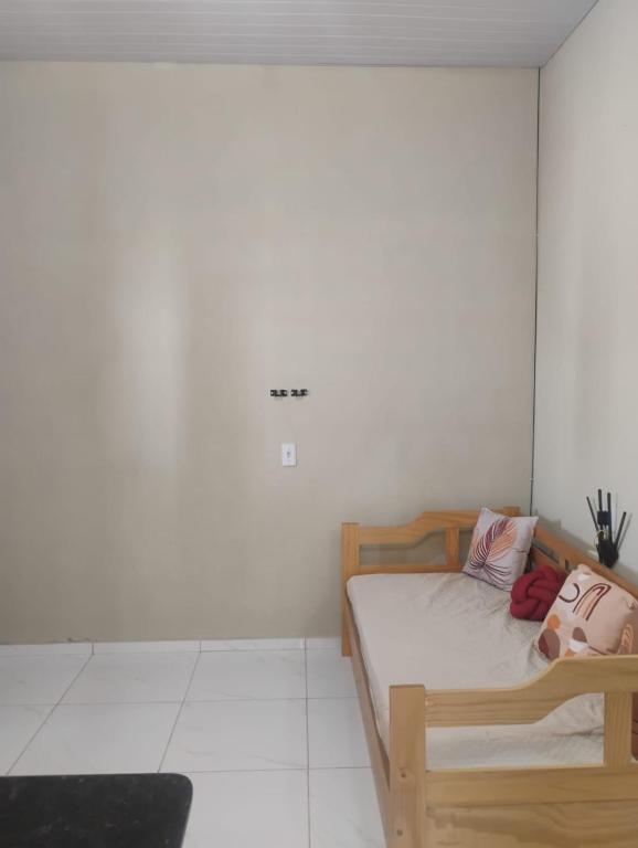 ein Schlafzimmer mit einem Holzbett in einem Zimmer in der Unterkunft Casa de greicy e ledilson in Beberibe