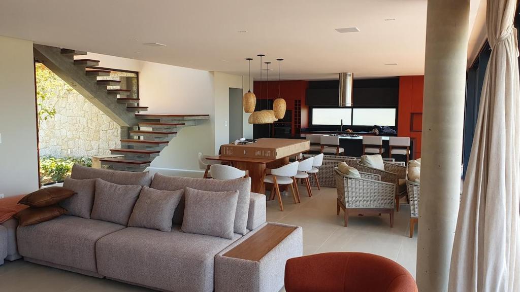 a living room with a couch and a dining room at Casa Céu do Siriú in Garopaba