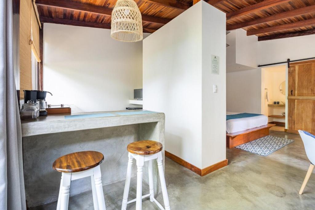 una cucina con bancone e due sgabelli in una stanza di La Buena vida Cabina 4 a Playa Grande