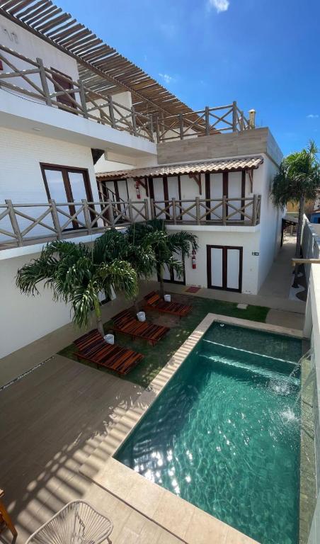 a house with a swimming pool in front of a house at Pousada Solarium in Canoa Quebrada