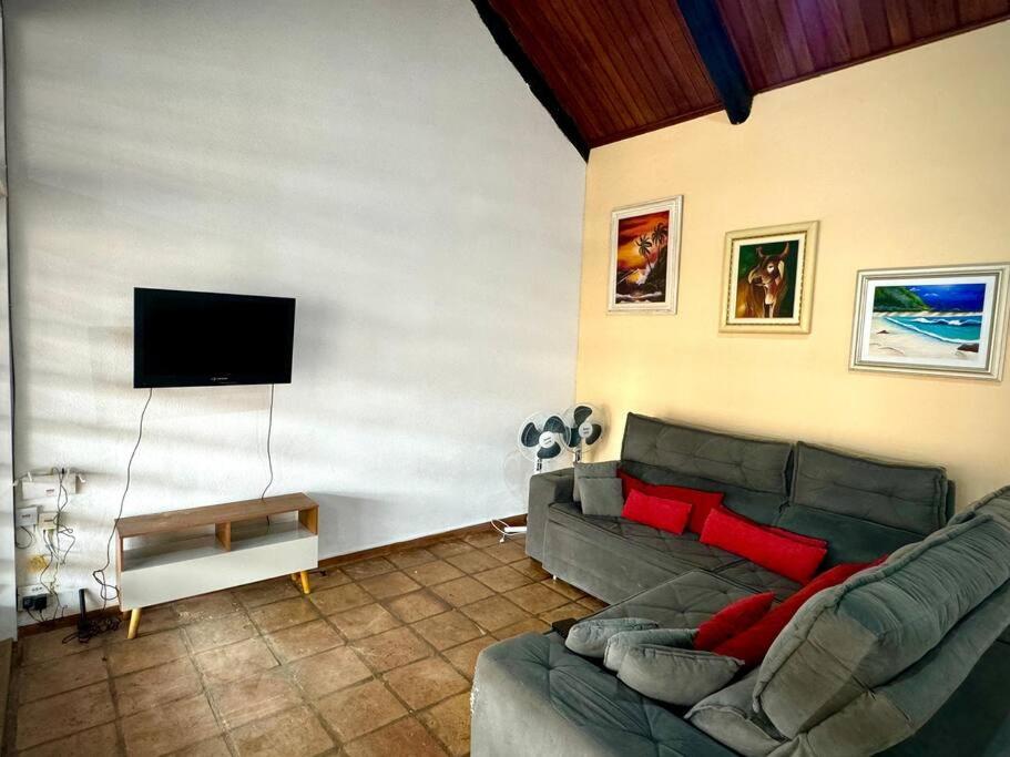 un soggiorno con divano e TV a schermo piatto di Casa na Praia dos Pesacdores a Itanhaém