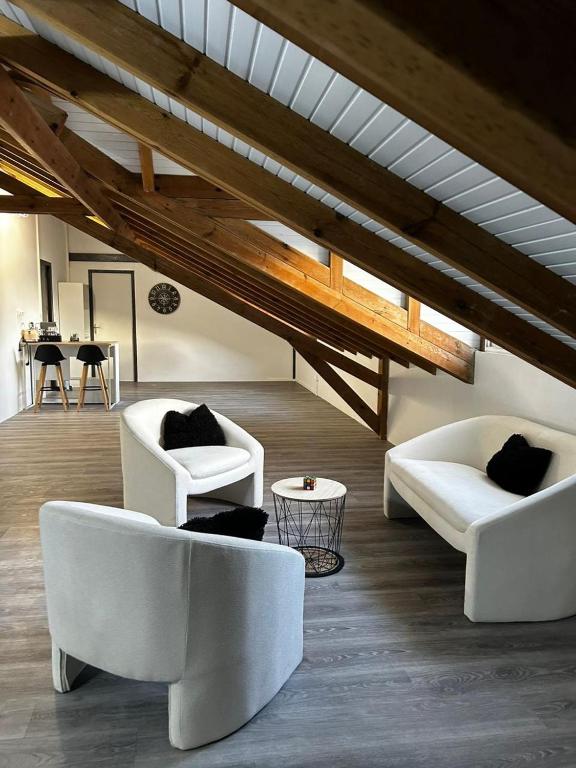 ein Wohnzimmer mit zwei weißen Stühlen und einem Tisch in der Unterkunft Bel Horizon in La Désirade