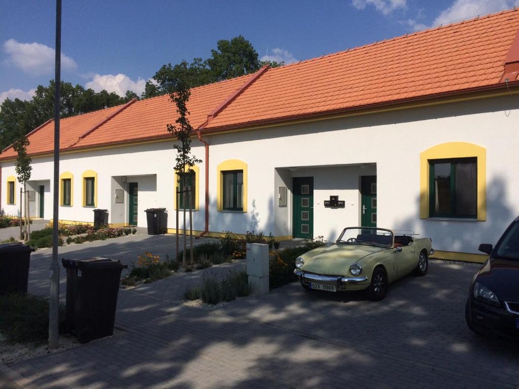 een groene auto geparkeerd voor een wit gebouw bij Apartmány Hlohovec in Hlohovec