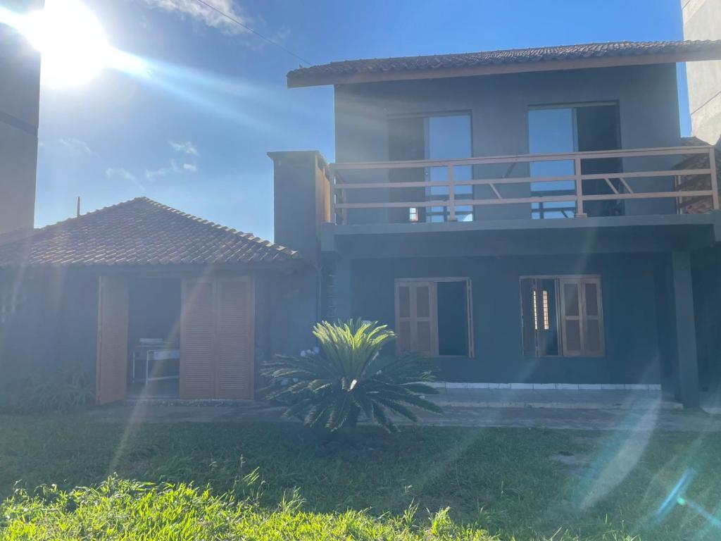 a house with a palm tree in front of it at Casa com piscina in Tramandaí
