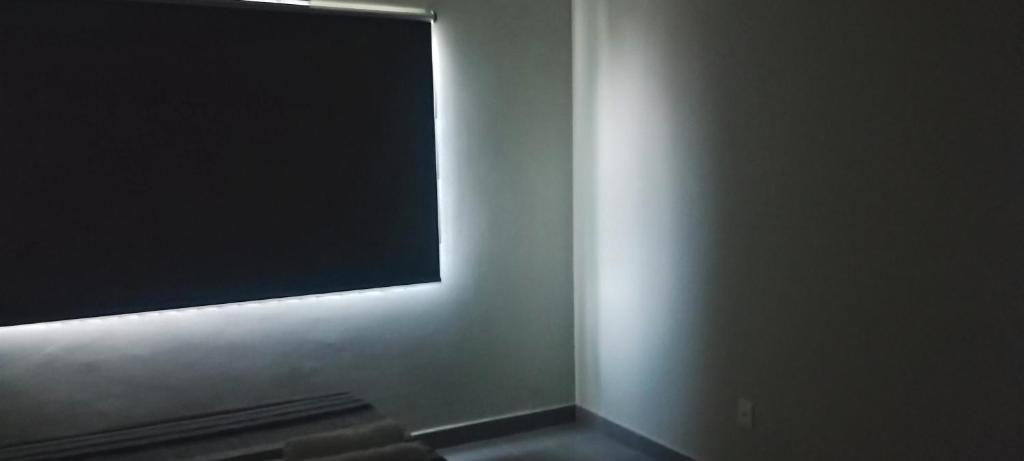 een flatscreen-tv aan een muur in een kamer bij Litoral suítes in Araruama