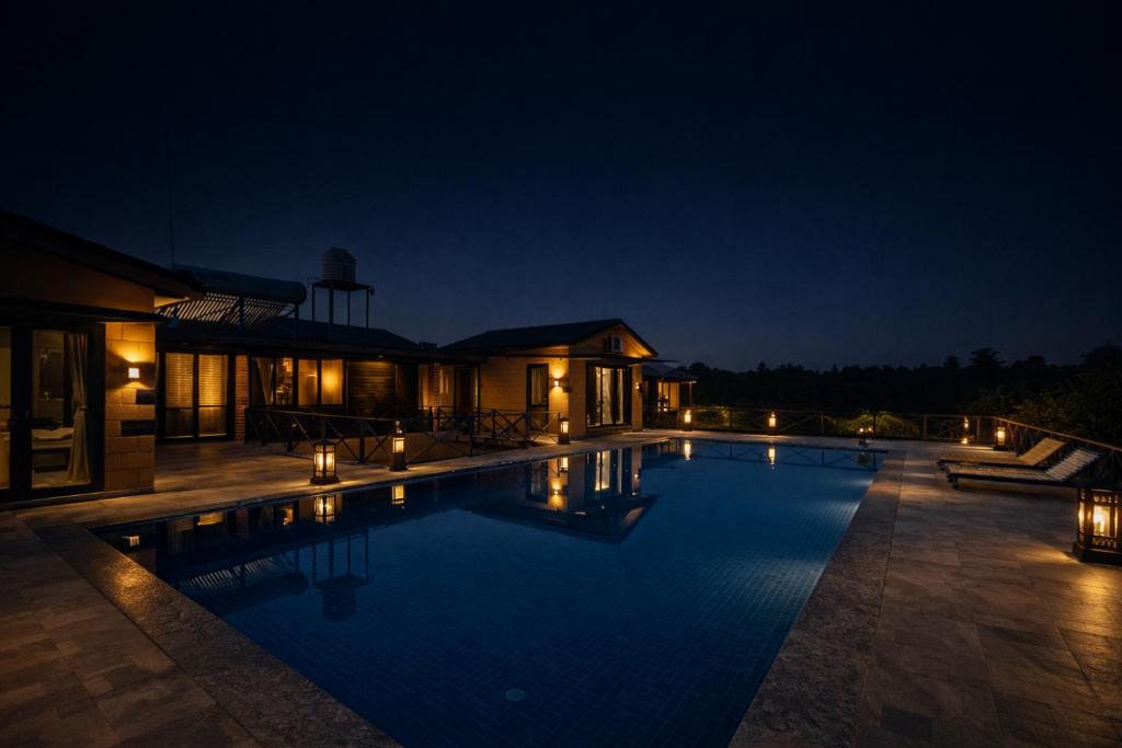 萨三吉尔Whispering Woods Chalet的夜间游泳池周围灯光环绕