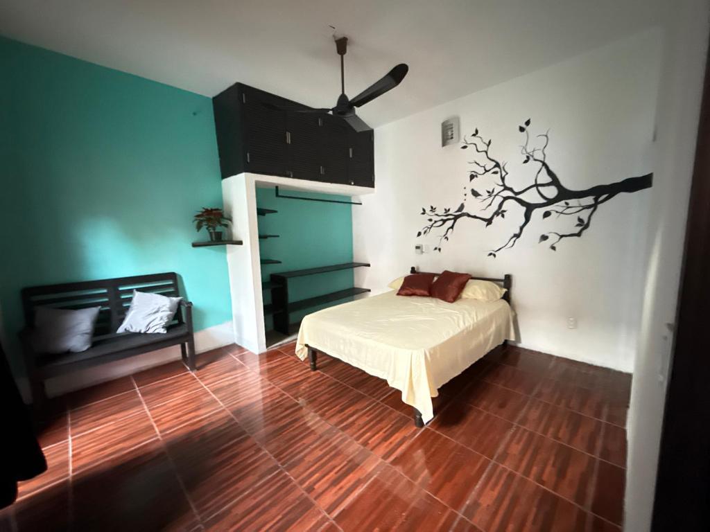 een slaapkamer met een bed en een boom aan de muur bij Casa LA ROCA in Zipolite