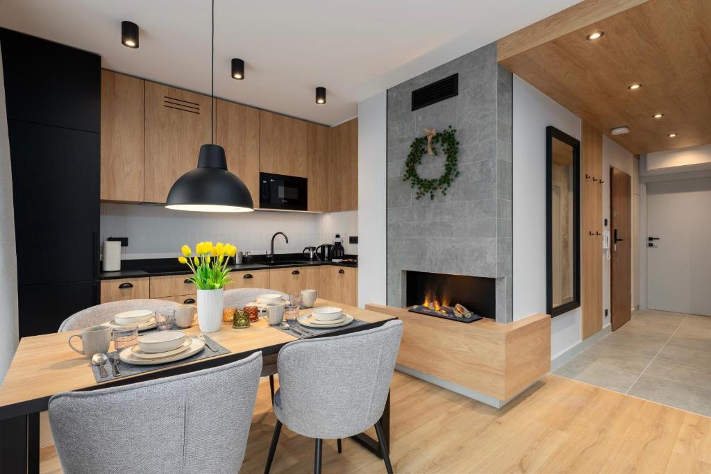 a kitchen and dining room with a fireplace at REST4U APARTAMENTY z SAUNAMI in Szczyrk
