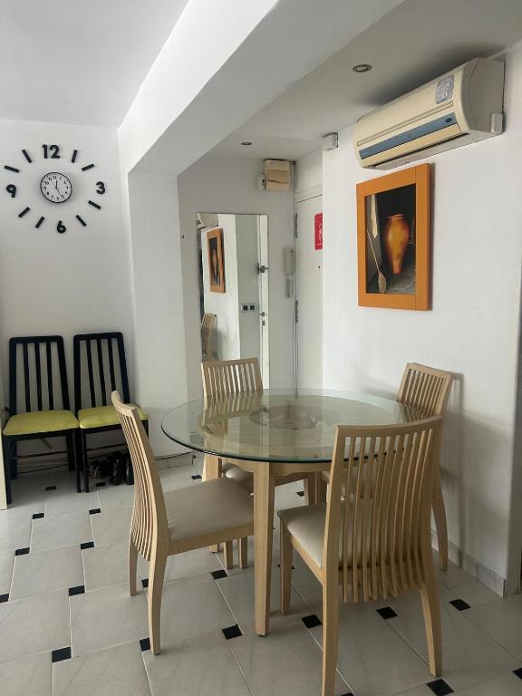una sala da pranzo con tavolo e sedie in vetro di Benidorm Apartament a Benidorm