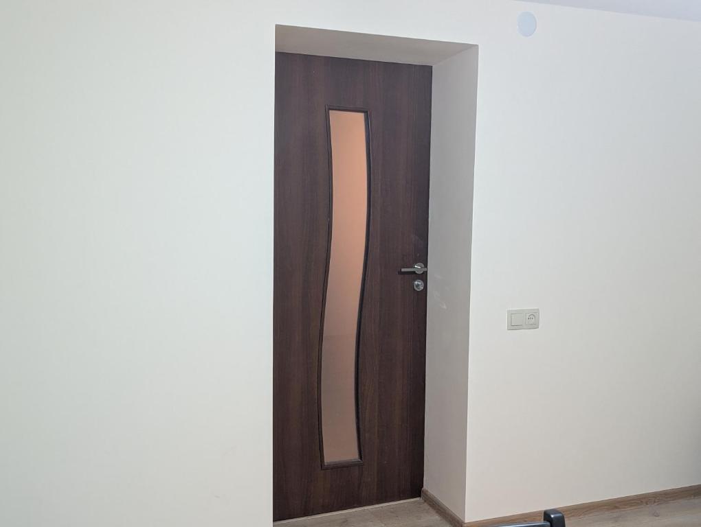 een kamer met een houten deur en een spiegel bij Home Sweet in Balaovit