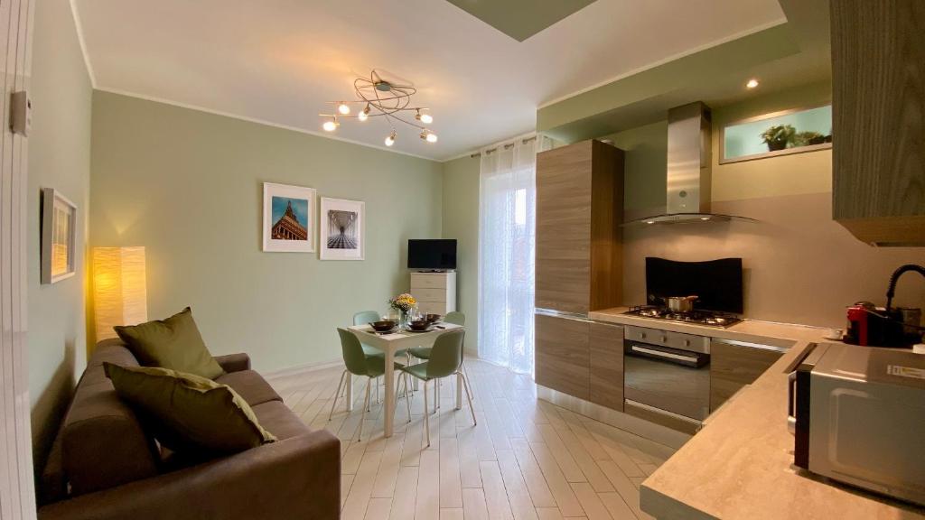 een woonkamer en keuken met een bank en een tafel bij Il Bumbunin di Collegno in Collegno