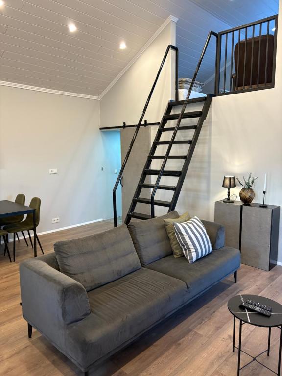 uma sala de estar com um sofá e uma escada em Brim Guesthouse, with ocean view em Sauðárkrókur