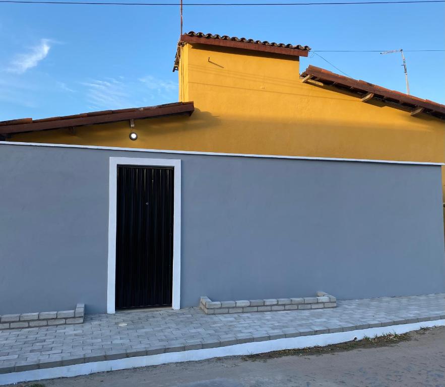 a yellow and white building with a door at BARRA NOVA CASCAVEL CEARÁ-Casa Solaris in Cascavel