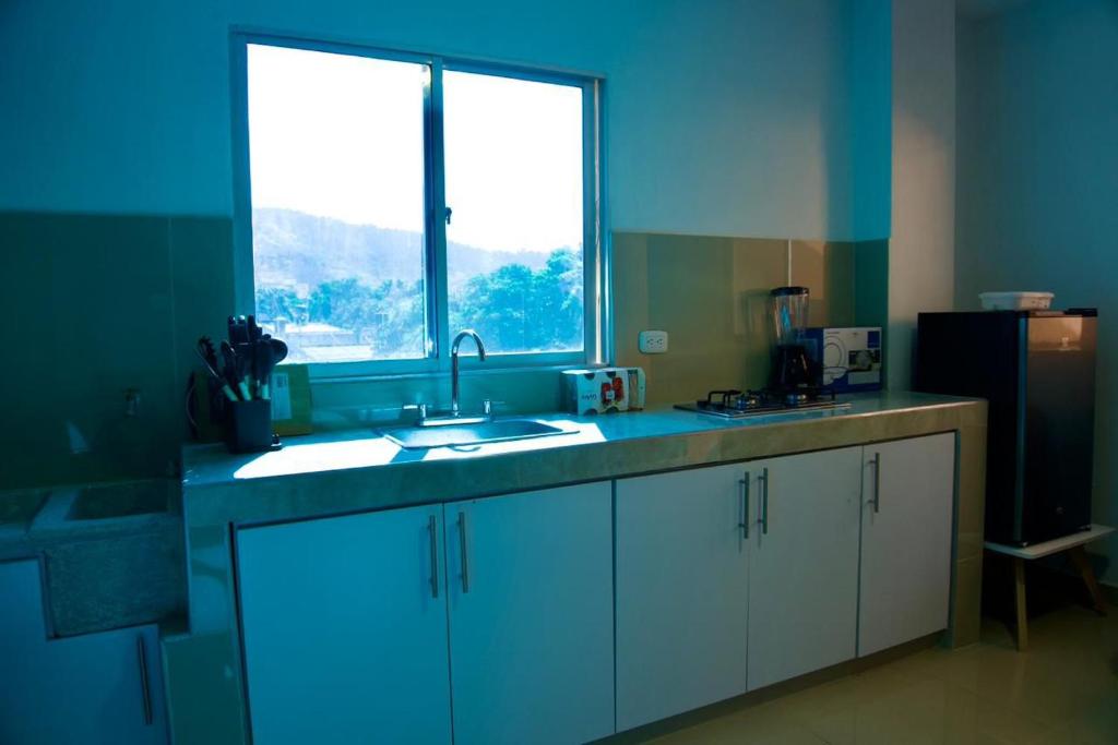 een keuken met een wastafel en een groot raam bij Gairaka 3 in Gaira