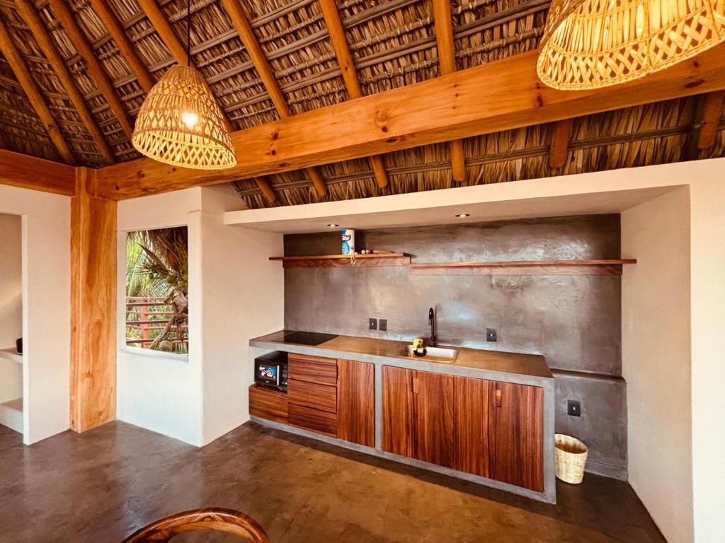 een keuken met een wastafel en een houten plafond bij Punta Arena Surf Suites in Puerto Escondido