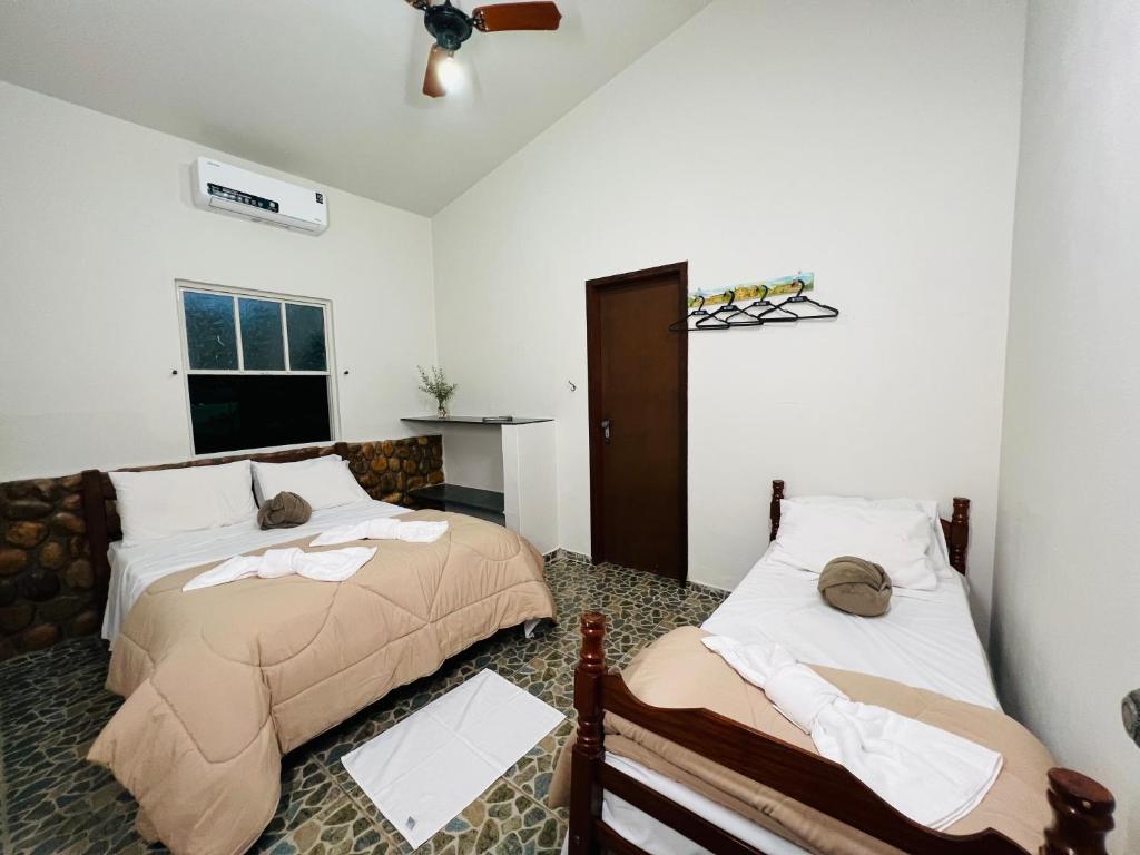 a bedroom with two beds and a ceiling fan at Pousada Horizonte da Canastra in São Roque de Minas