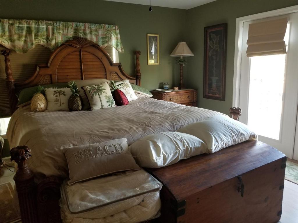 een slaapkamer met een groot bed met een houten hoofdeinde bij Oceanfront 3BR/2BA with Jacuzzi in Vero Beach in Sebastian