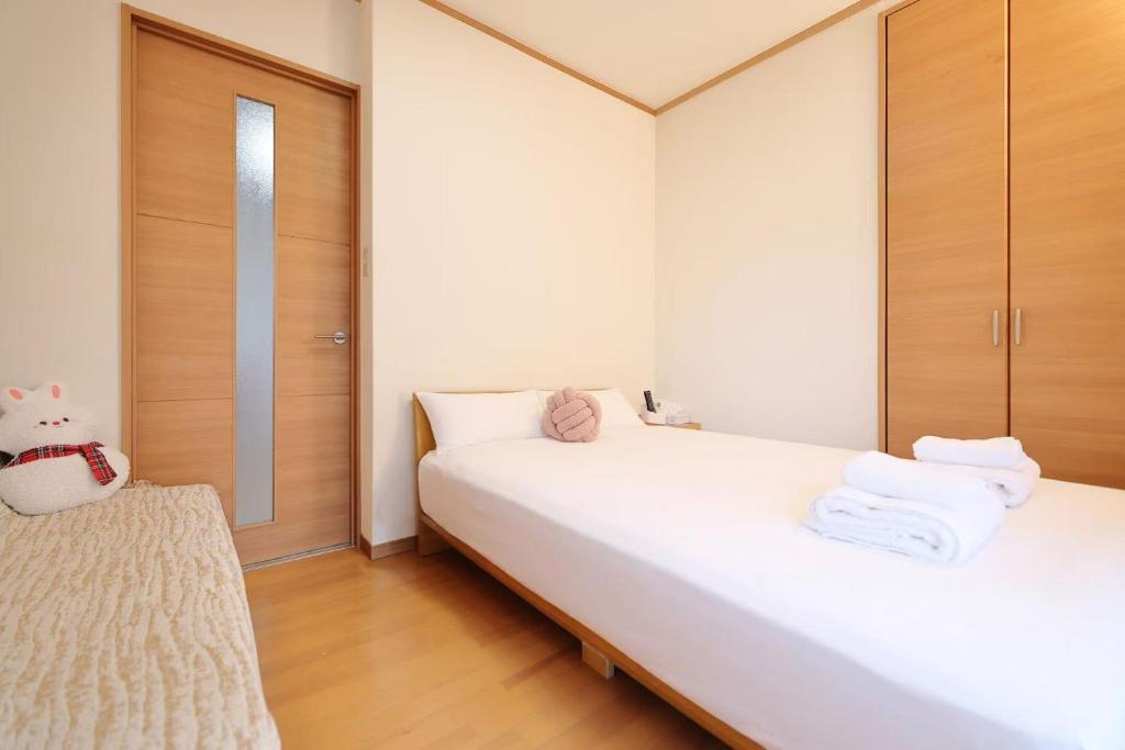 ein Schlafzimmer mit 2 Betten und weißen Handtüchern darauf in der Unterkunft 3 min JR Direct to Skytree Asakusa Shinjuku Sea Heim in Tokio