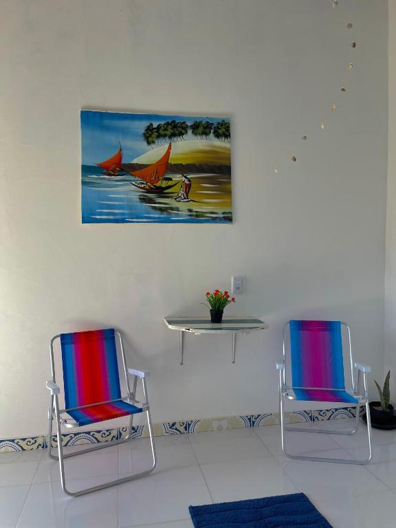 twee stoelen en een tafel en een schilderij aan de muur bij Solar da Pérola in Salvaterra