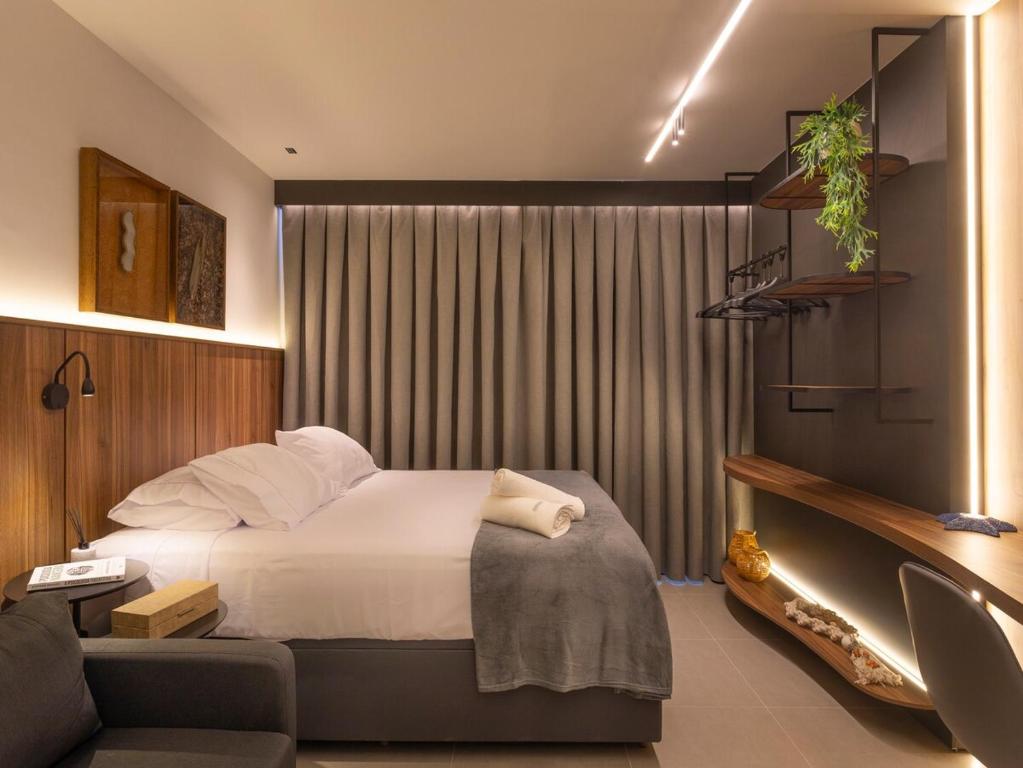 een hotelkamer met een bed en een bank bij Flat novo de luxo na melhor área da praia de Ponta de Campina! in Cabedelo