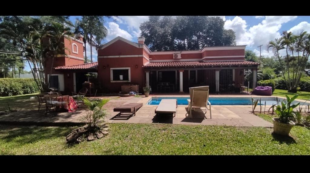 a house with a swimming pool in front of it at La Gloria in Paso de la Patria