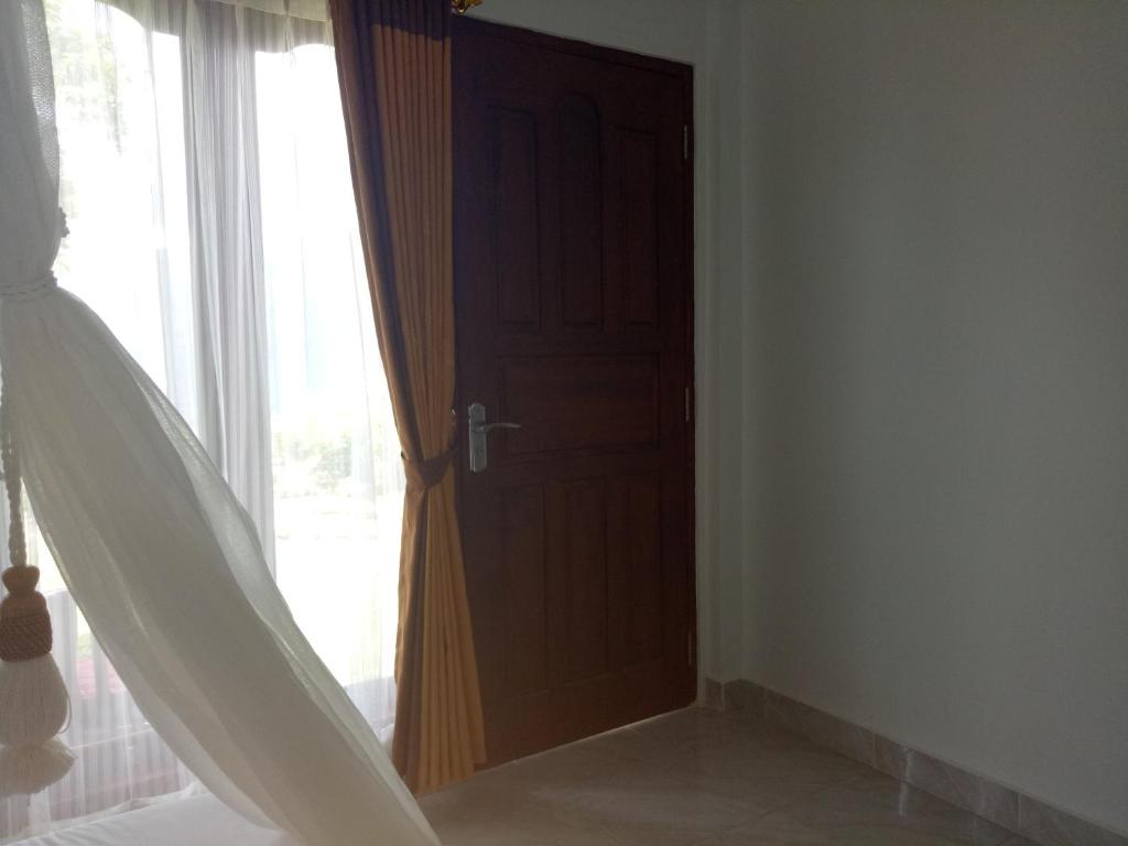 Postel nebo postele na pokoji v ubytování Aris Homestay and Warung Made